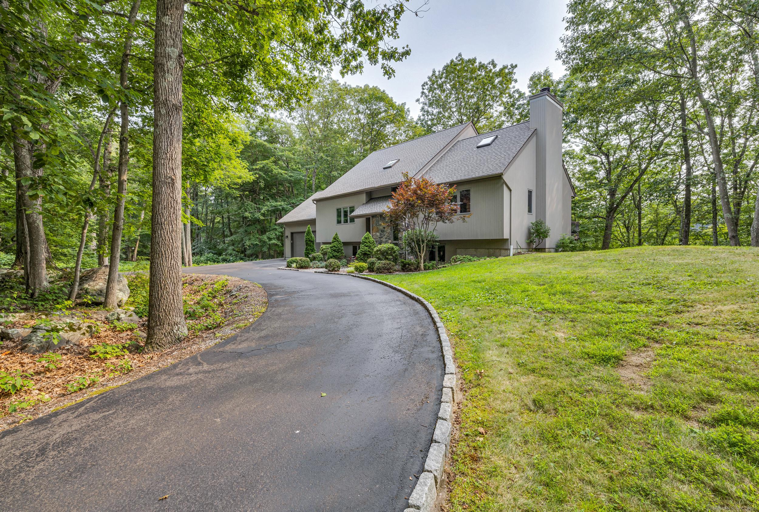 Image 2Front Yard: Ideally situated one a 1-acre lot nestled along the salt marshes of Long Island Sound.