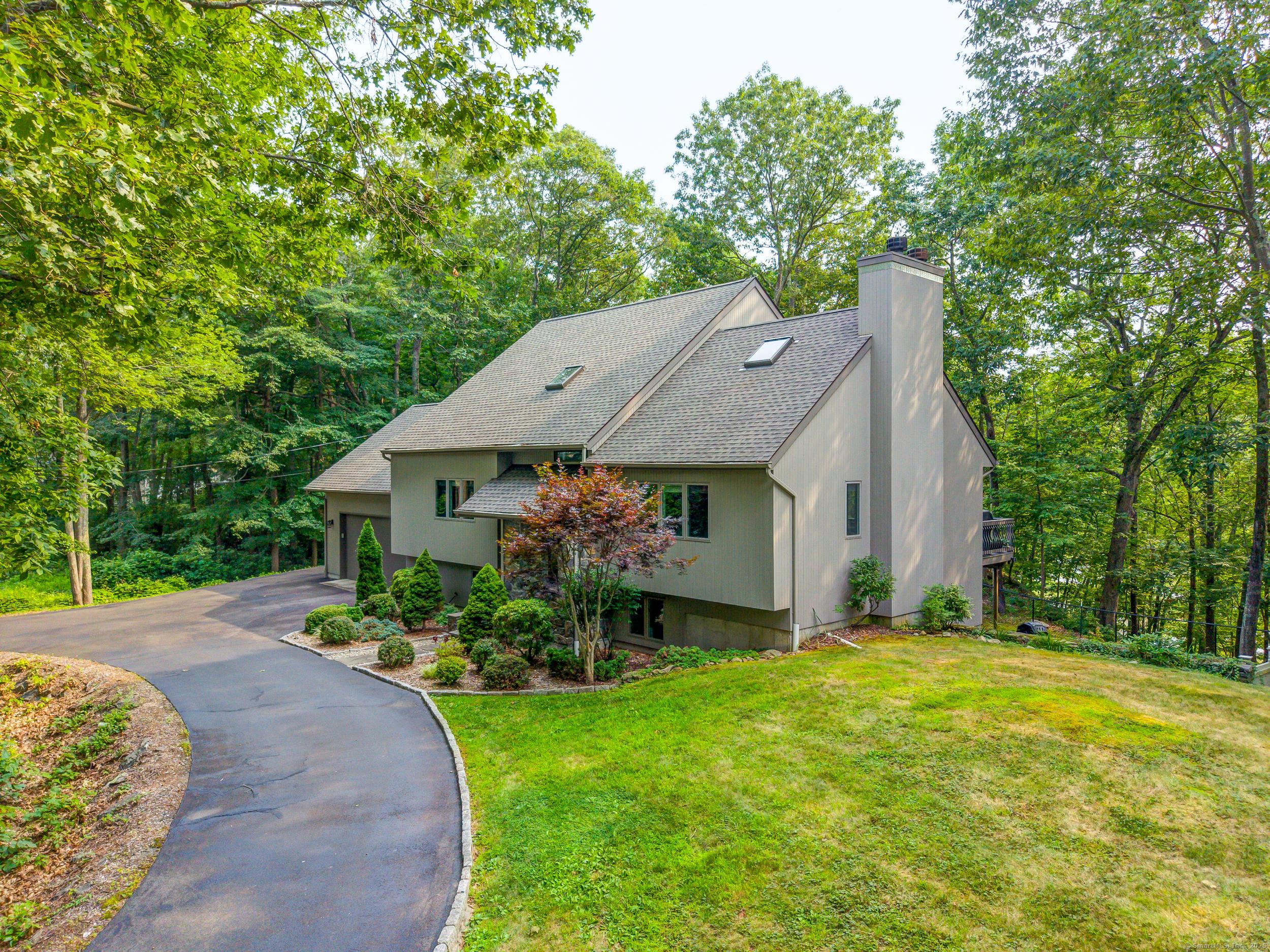 Image 3Front of House: Mature trees and plantings, natural rock outcroppings offer a peaceful retreat.