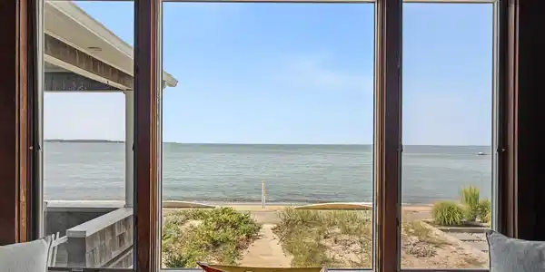 Image 4: Inside, this large window captures the oceanscape beyond when you enter the house!