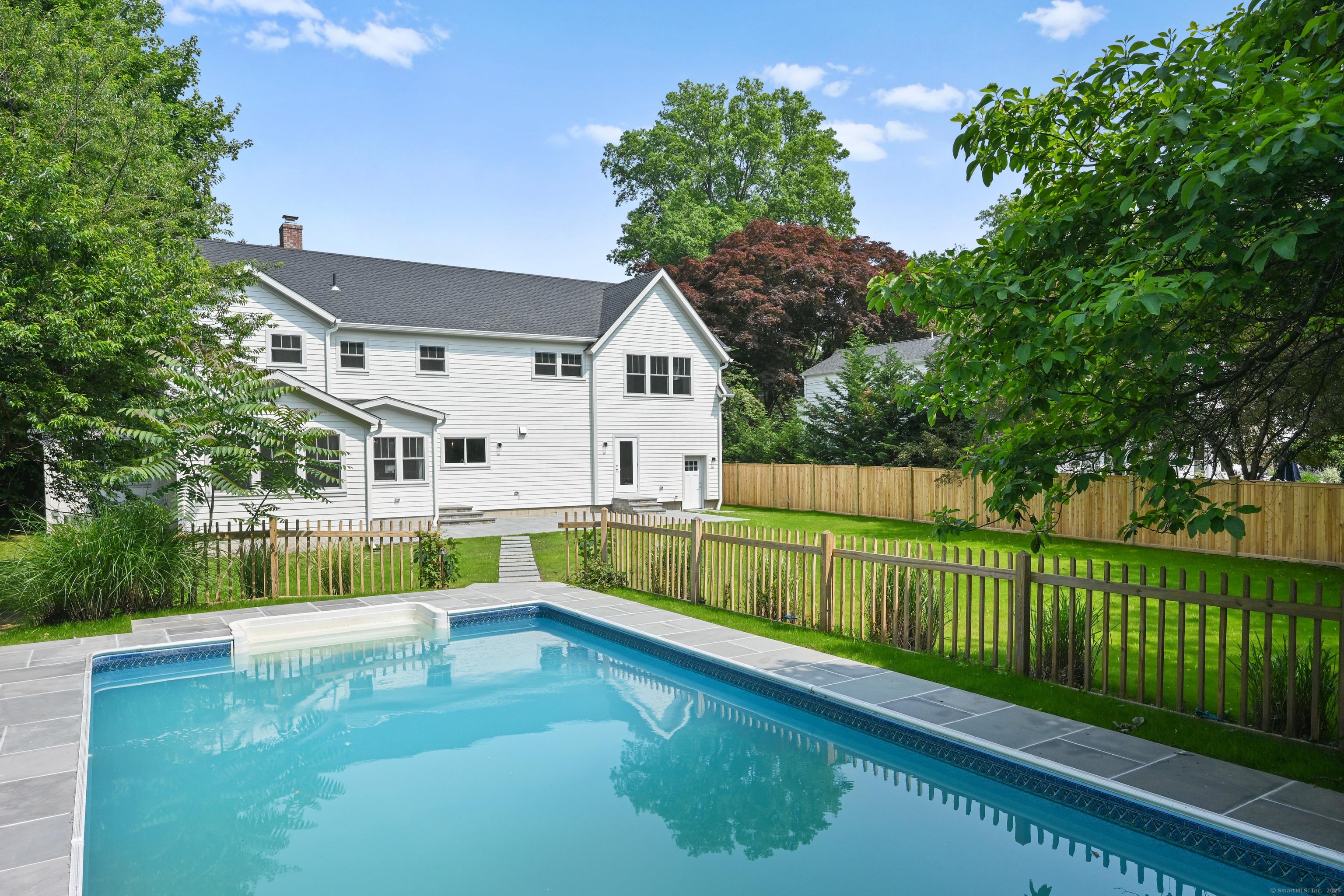 Image 3Back of House: over a half acre of flat property with lovely pool and expansive blue stone patio