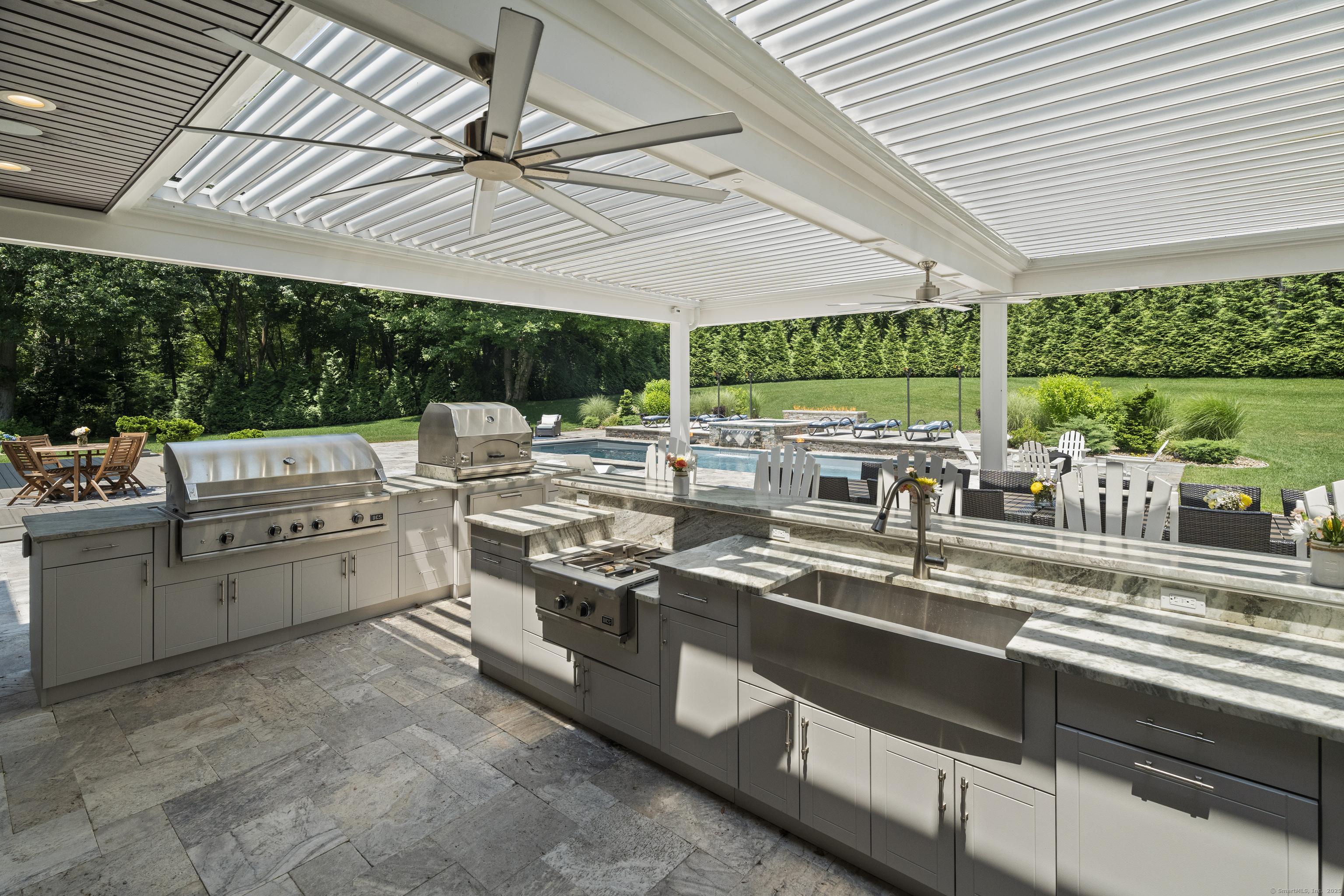 Image 3Kitchen: outdoor kitchen with lifetime marine-grade cabinets, granite countertops and premium appliances including a DCS Series 9 Grill and Lynx pizza oven, refrigerators and an outdoor 75" Samsung Terrace TV with waterproof Sonos Arc soundbar 