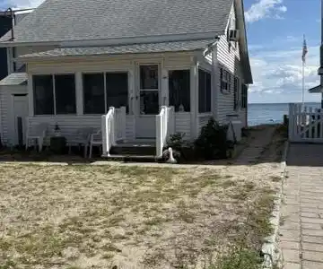 Image 4Back of House: Street side view of back porch and ample parking for owners and guests.