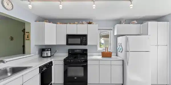 Image 3Kitchen: The fridge is newer and there are plenty of cabinets for proper kitchen storage.