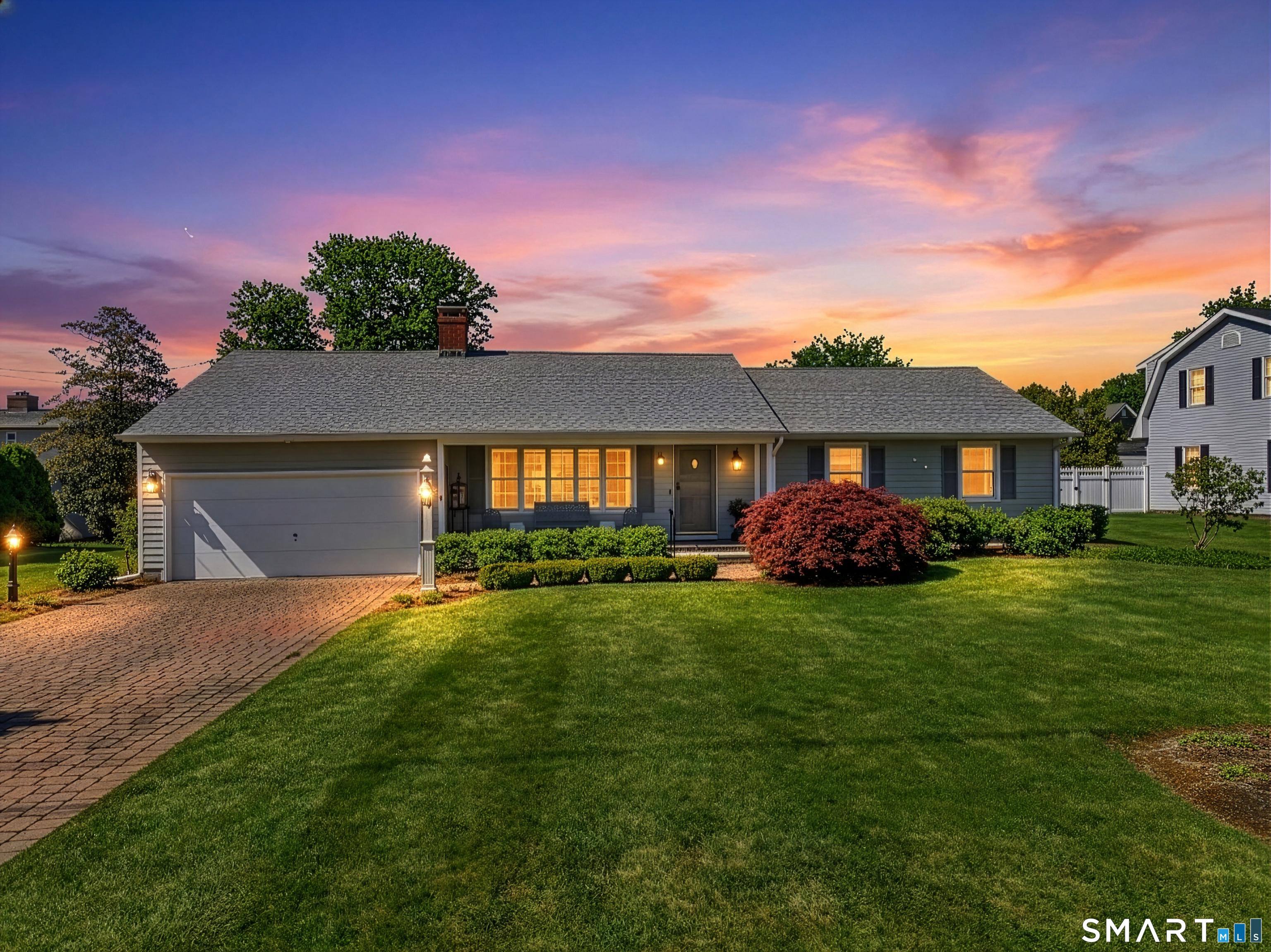 Image 1: Twilight shot of the exterior of the home