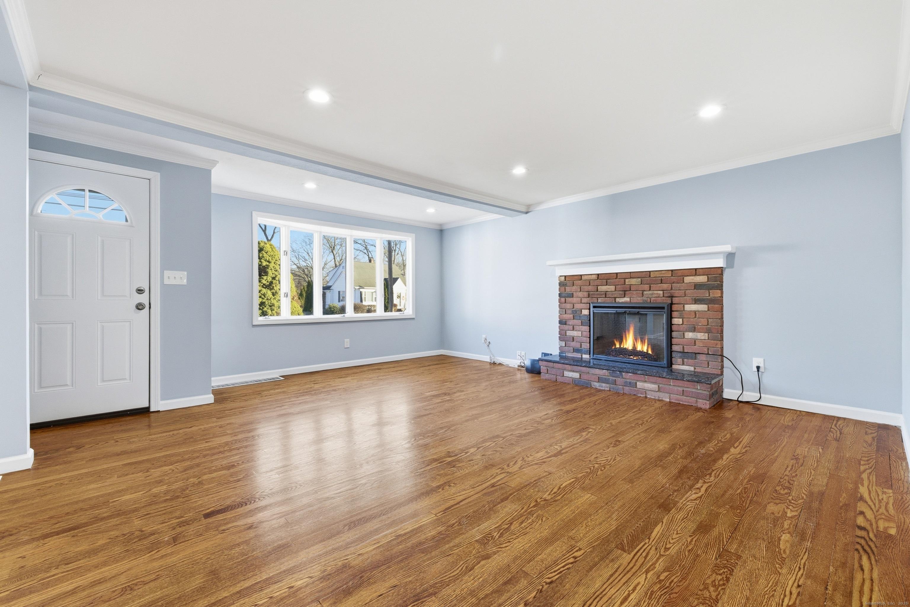 Image 2Living Room: Living room with fireplace offer space for a dining area. Gleaming hardwood floors and a large bay window.