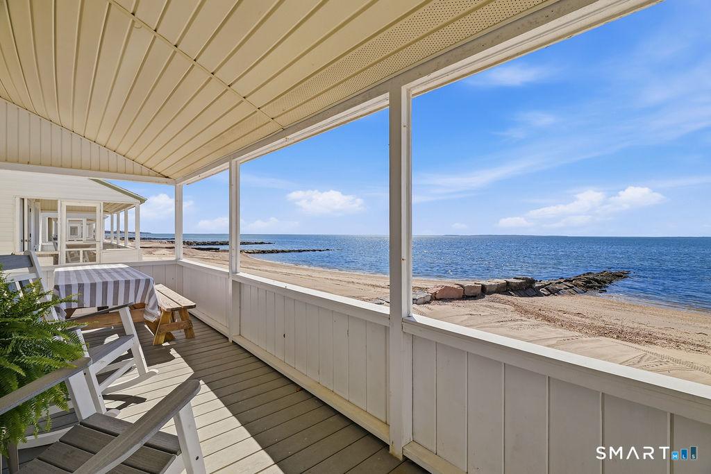 Image 4: A covered waterfront porch offers the perfect setting for long, lazy summer days spent relaxing by the water.