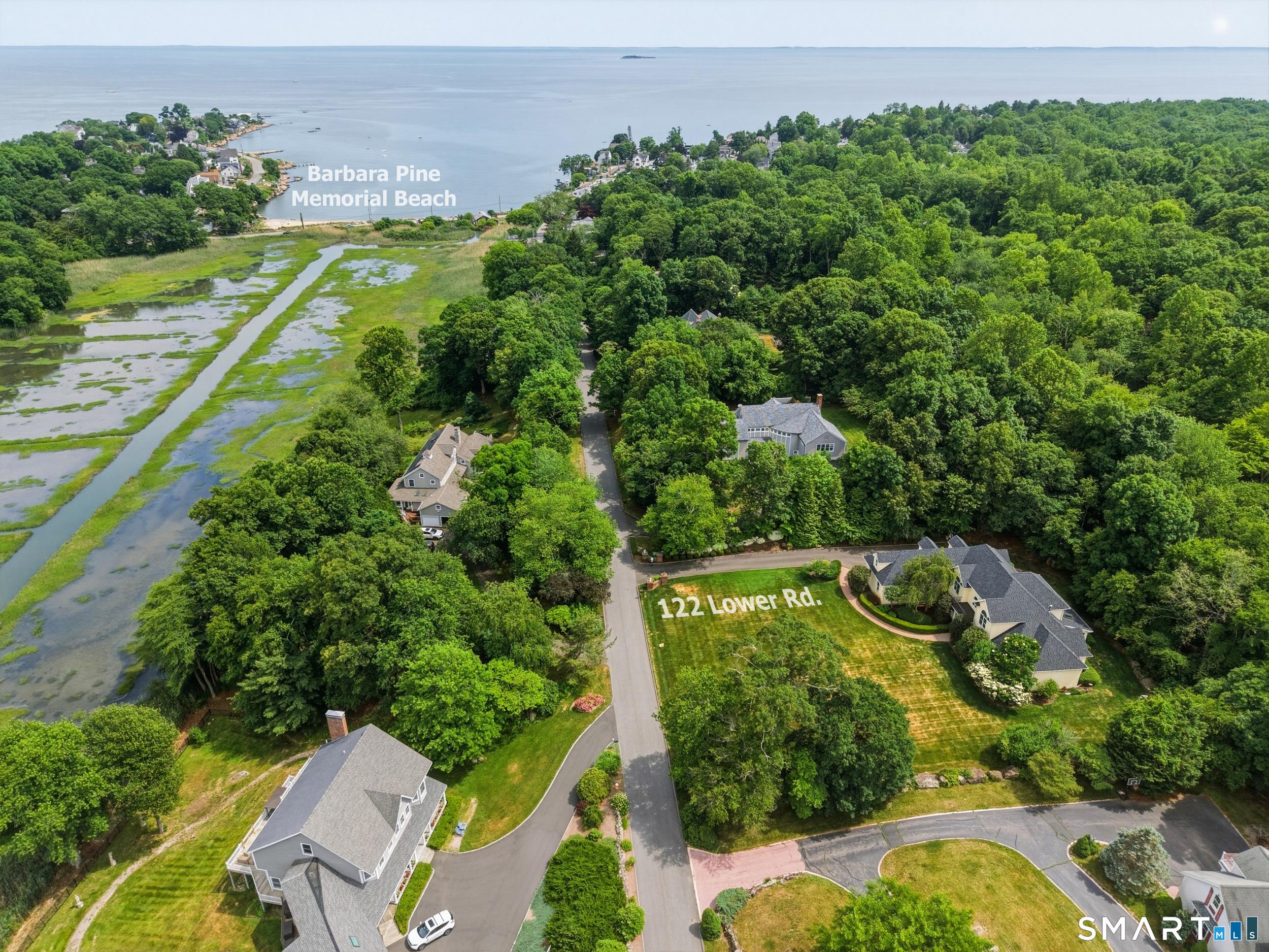 Image 1Aerial View: Aerial photo shows the property's close proximity to Barbara Pine Town Beach, offering easy access to shoreline recreation, swimming, kayaking, and picturesque coastal scenery.