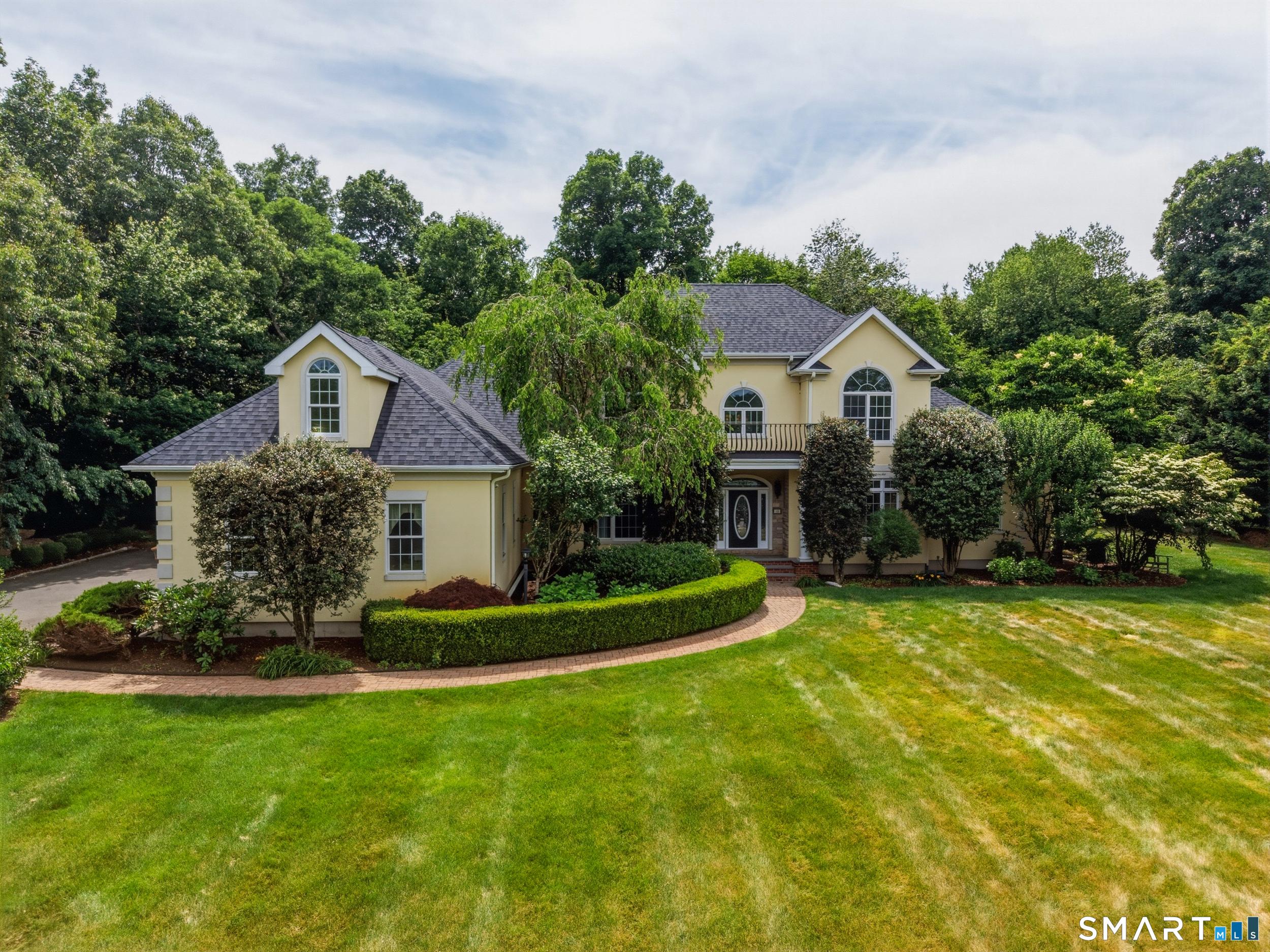 Image 2Front of House: WELCOME HOME... Nestled on a beautifully landscaped 1.84-acre lot, this property offers lovely curb appeal with a lush lawn, mature plantings and specimen trees that create a picturesque setting.