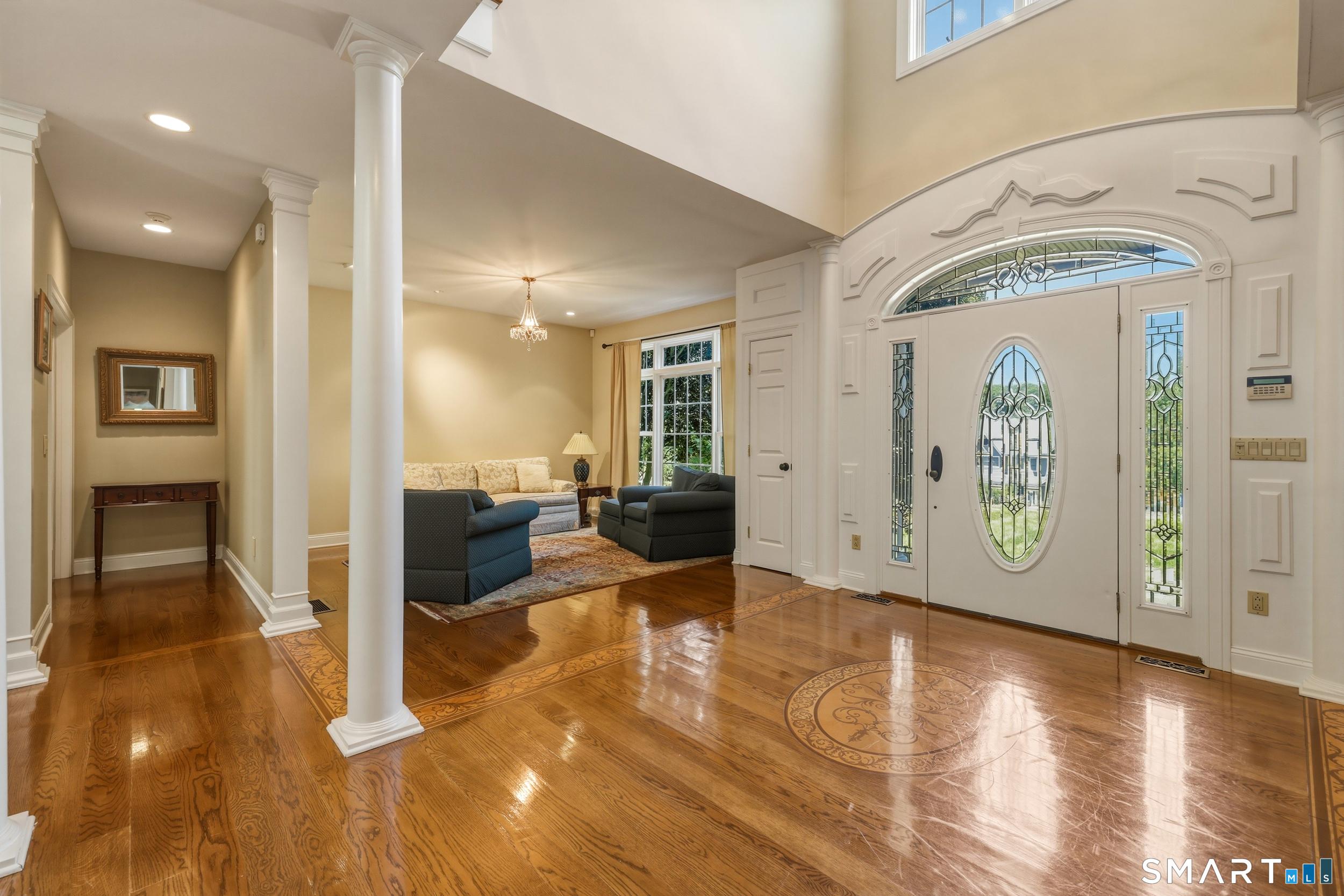 Image 4Foyer: Step into the two-story foyer, where hardwood flooring and an elegant inlaid medallion design create a striking first impression. Flanked by living and dining rooms.
