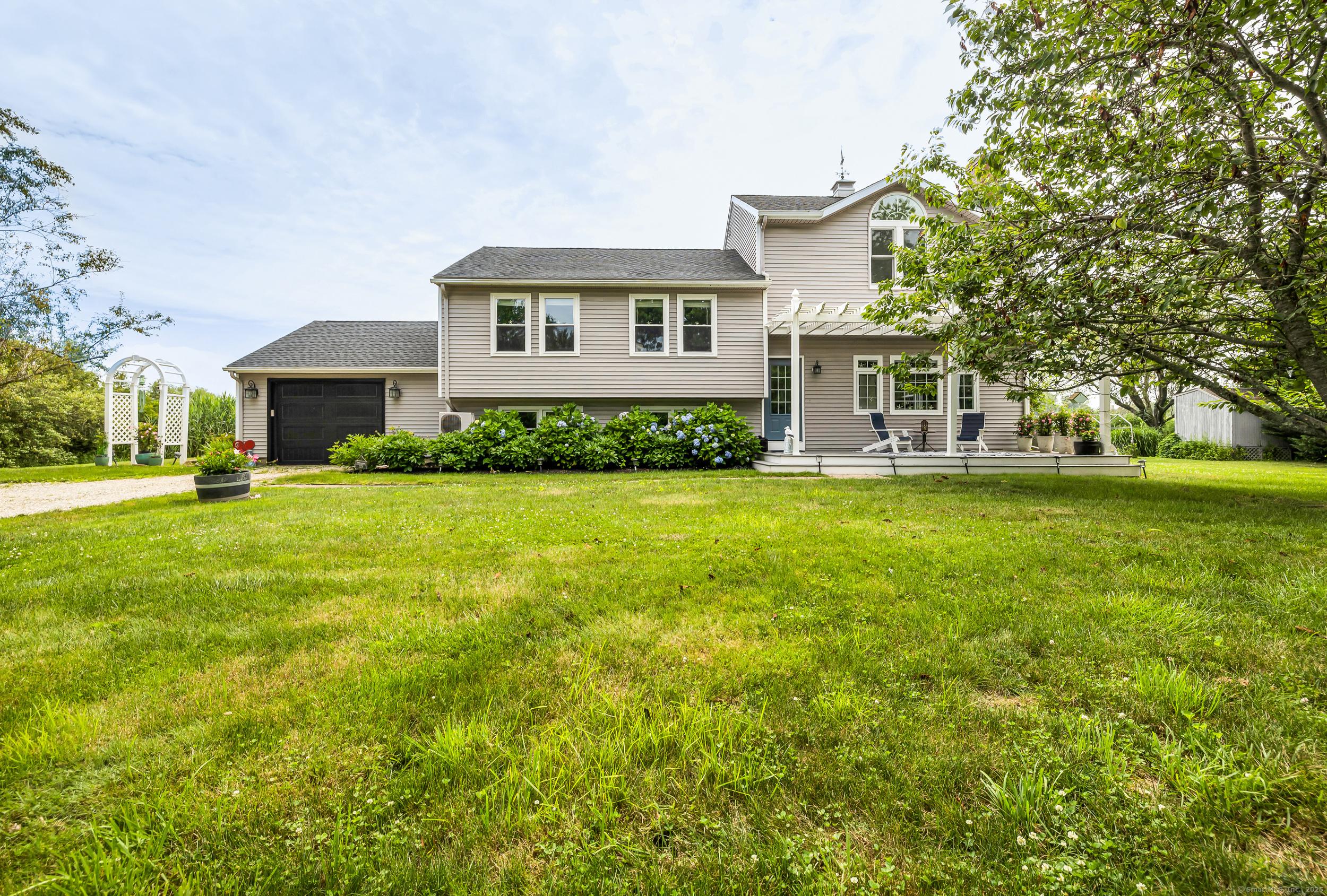Image 2Front of House: Highly desirable location... down a sidewalk road from the historic Guilford Green and other local attractions. Peaceful surroundings, lush lawn, perennial gardens, and the occasional woodland visitors.