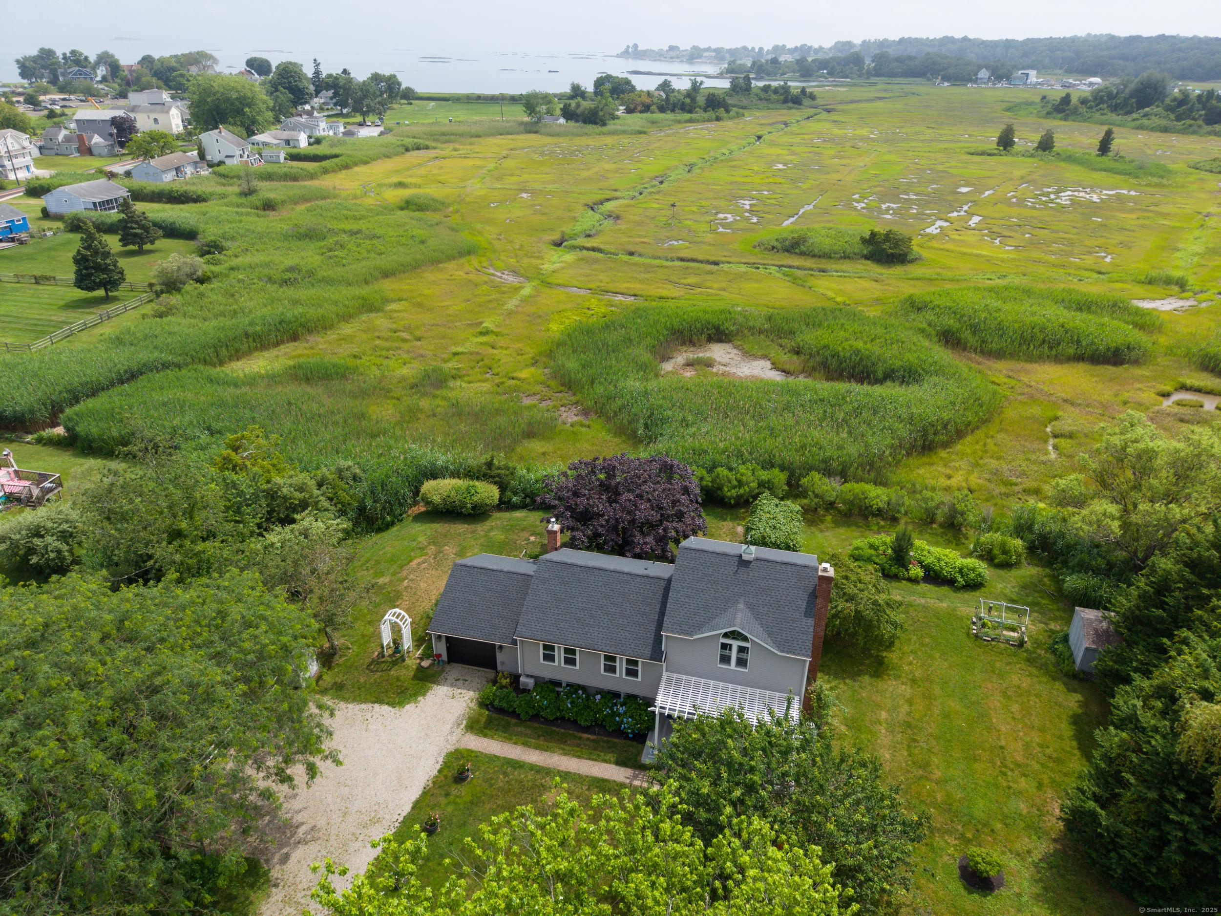 Image 3Aerial View: Over 2,000 SF of finished living space, sitting on a 1-acre private lot set back from Whitfield Street offering fabulous view of the salt marsh and Long Island Sound beyond.