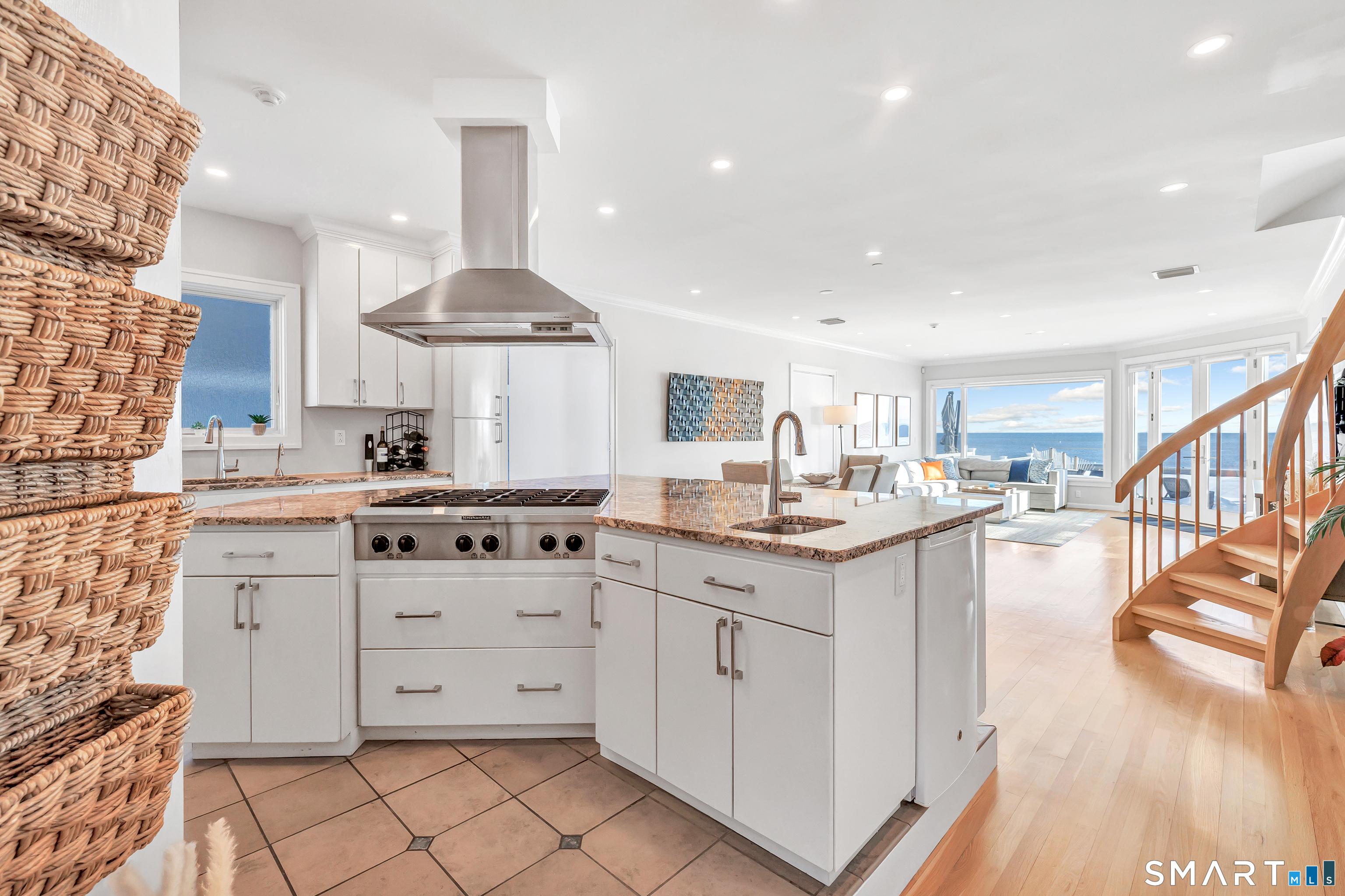 Image 3Kitchen: Sun-filled custom wood kitchen with recently upgraded cabinet hardware, 6-burner pro-grade cooktop, and Bosch dishwasher. Large center island with 3-person breakfast bar.