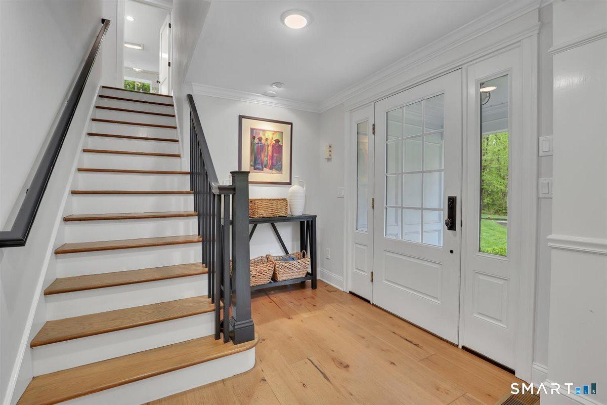 Image 4Entrance Foyer: Front entry foyer opens seamlessly into the living room, with the kitchen situated beyond for an easy, flowing layout ideal for everyday living and entertaining. A primary staircase leads to the three bedrooms on the upper level.
