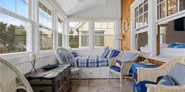 Image 4Sun Porch: Enter through the inviting sunroom and feel the warmth and beauty of the natural light. Updates include heated floors, new windows and automatic electric blinds which lower with just a click of a button.