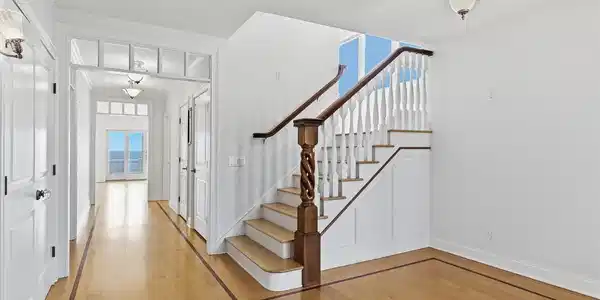 Image 3: Elegant foyer with custom architectural detail such as sculpted stair post, transom windows, and beautiful inlay wood border