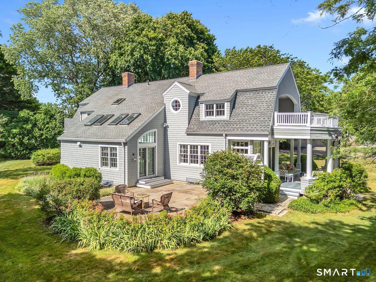 Image 4: Outdoor spaces include a generous bluestone patio and a covered porch with views of South Cove.