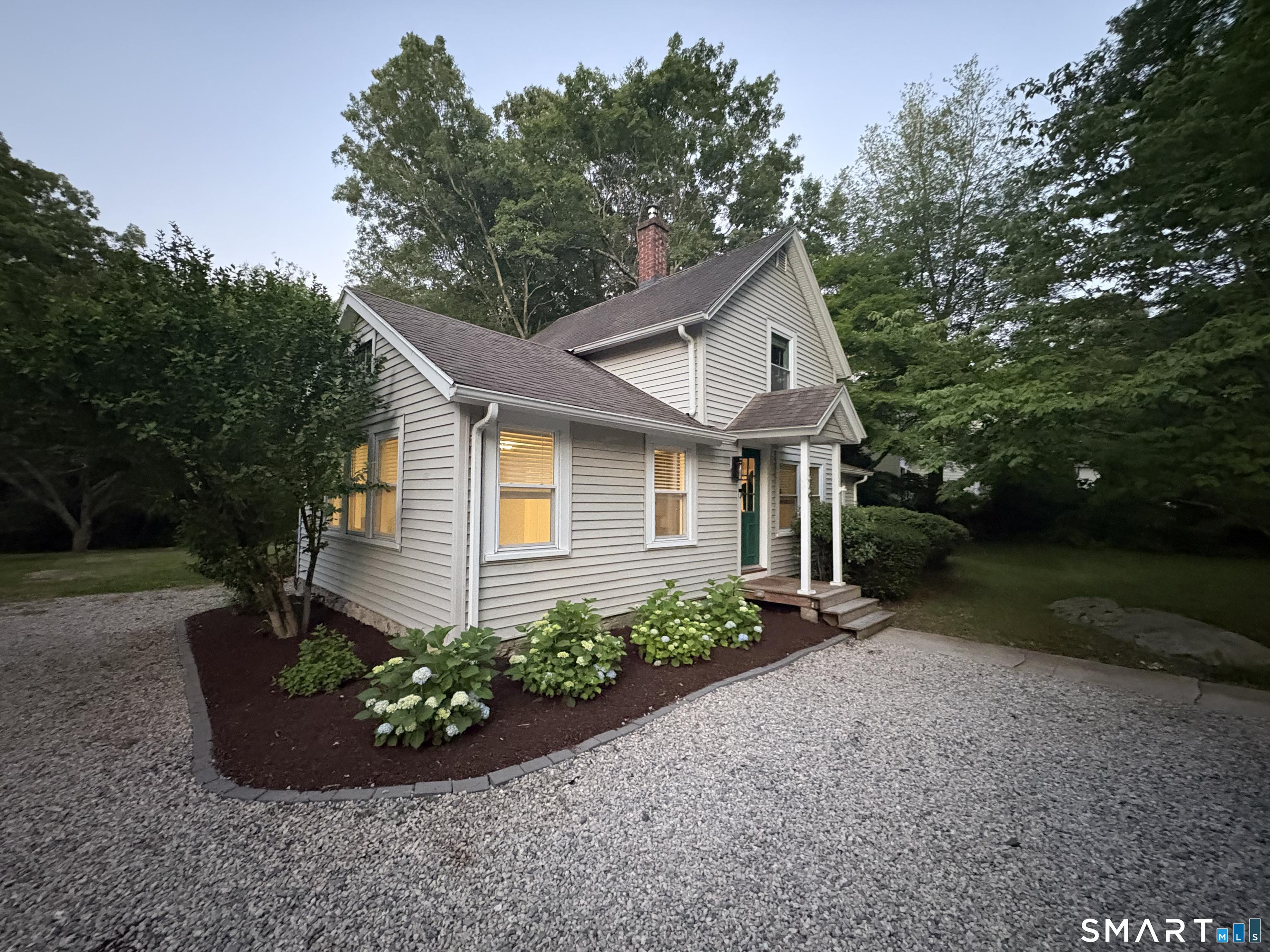 Image 1Front of House: Tucked away on over an acre of land along scenic Niantic River Road, this inviting circa-1900 farmhouse offers privacy, character, and seasonal views of the Niantic River.