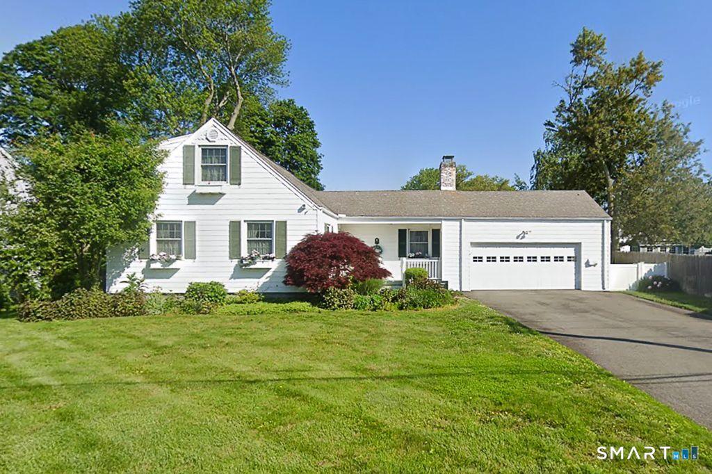 Image 3: Charming Cape-style home with classic white siding set on a spacious, level lot.