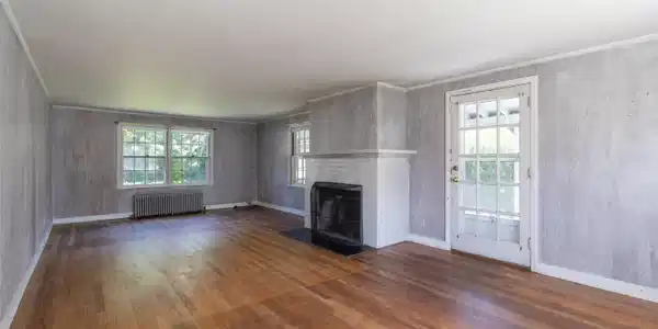 Image 4: The Living Room with fireplace. The door to the right leads to a screened porch. 