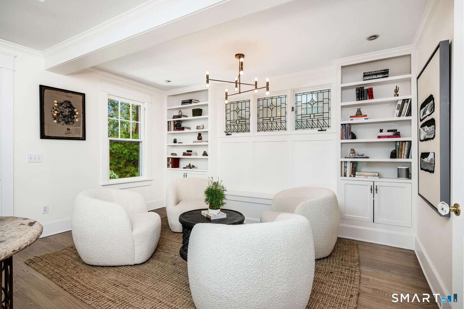 Image 4Living Room: Spacious living room featuring a cozy fireplace, built-in bookshelves, crown molding, and abundant natural light - ideal for relaxing and entertaining.