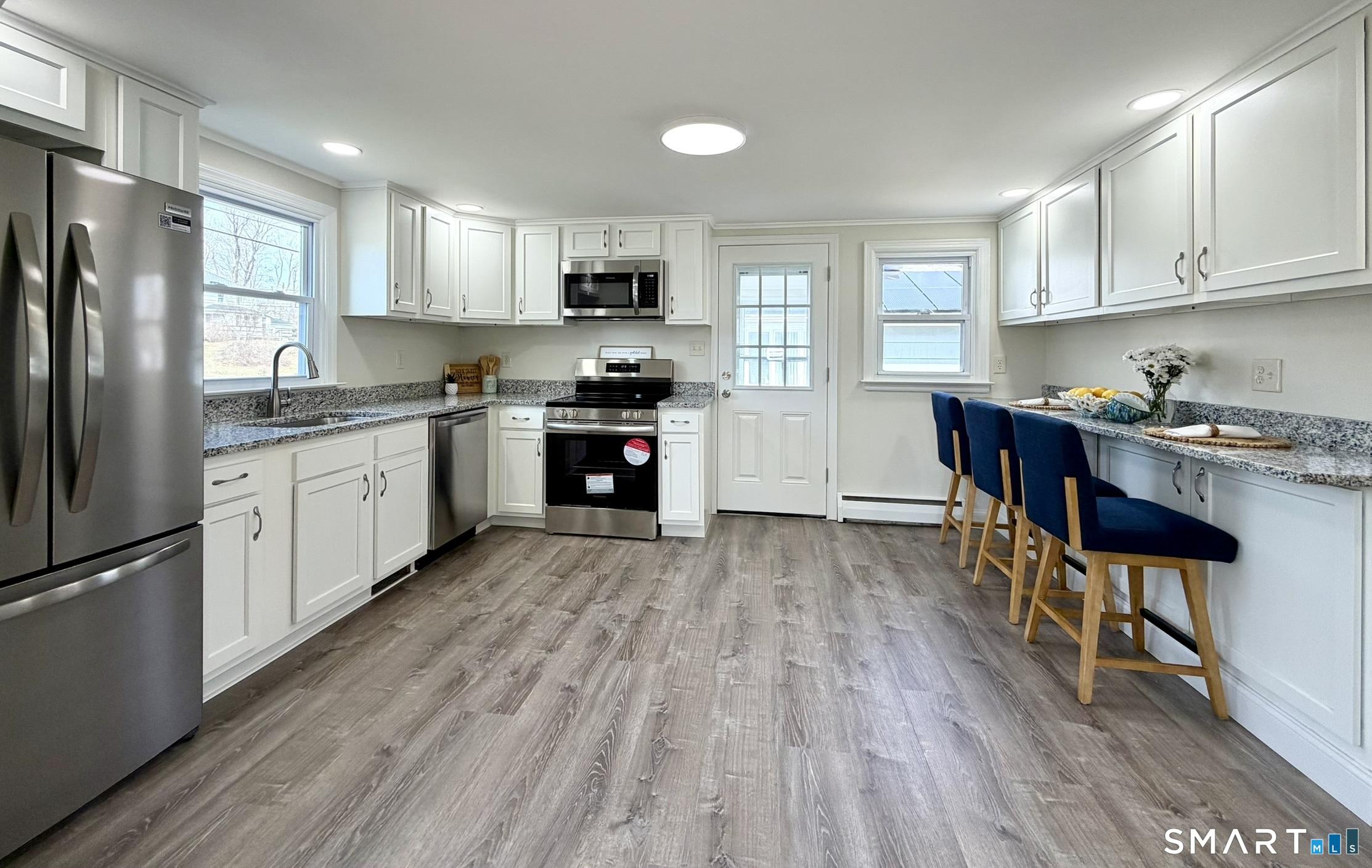 Image 2Kitchen: Stunning remodeled kitchen with granite countertops, white cabinetry & stainless steel appliances