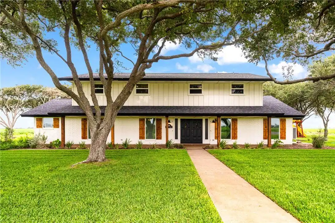 Image 1: Front view of a large ranch-style home featuring e
