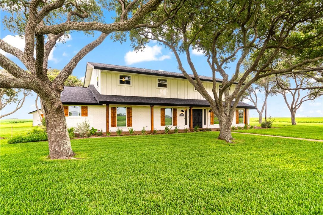 Image 2: Front view of a large ranch-style home featuring e