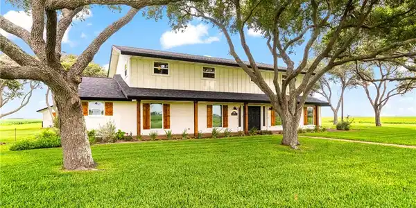 Image 2: Front view of a large ranch-style home featuring e
