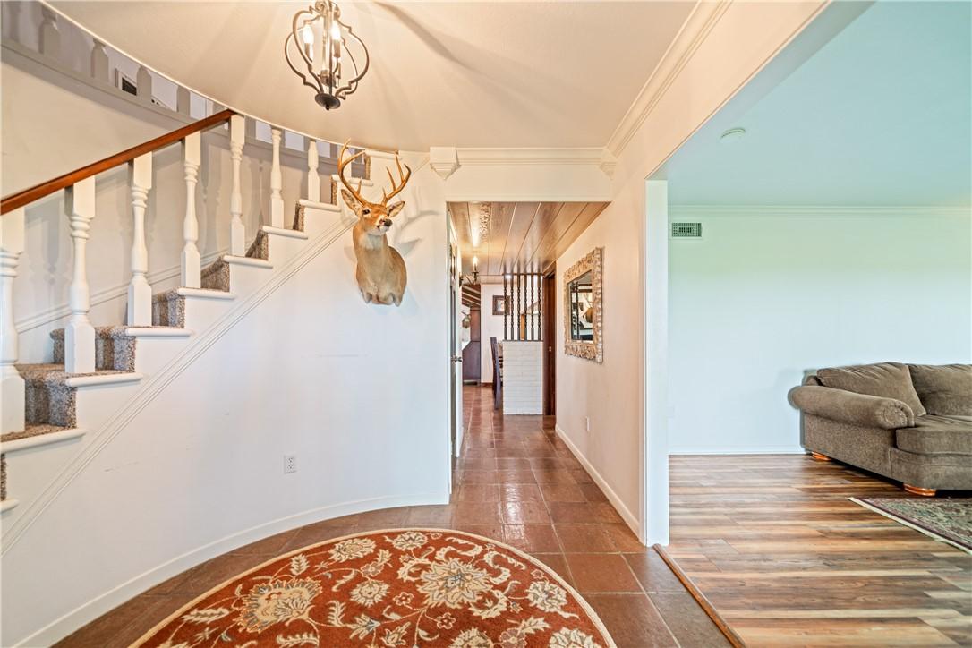 Image 3: Welcoming entry hall featuring a curved staircase,