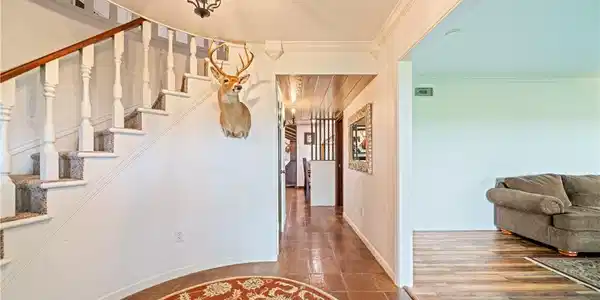 Image 3: Welcoming entry hall featuring a curved staircase,