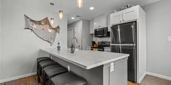Image 4: Sleek quartz countertops, pendant lighting, and cr