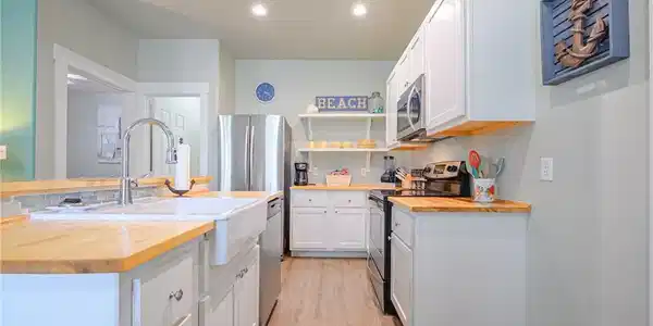 Image 3: Fully furnished kitchen with open flow to living a