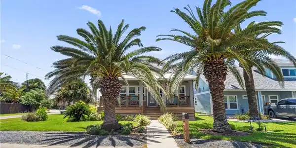 Image 2: Front view of the property with mature landscaping