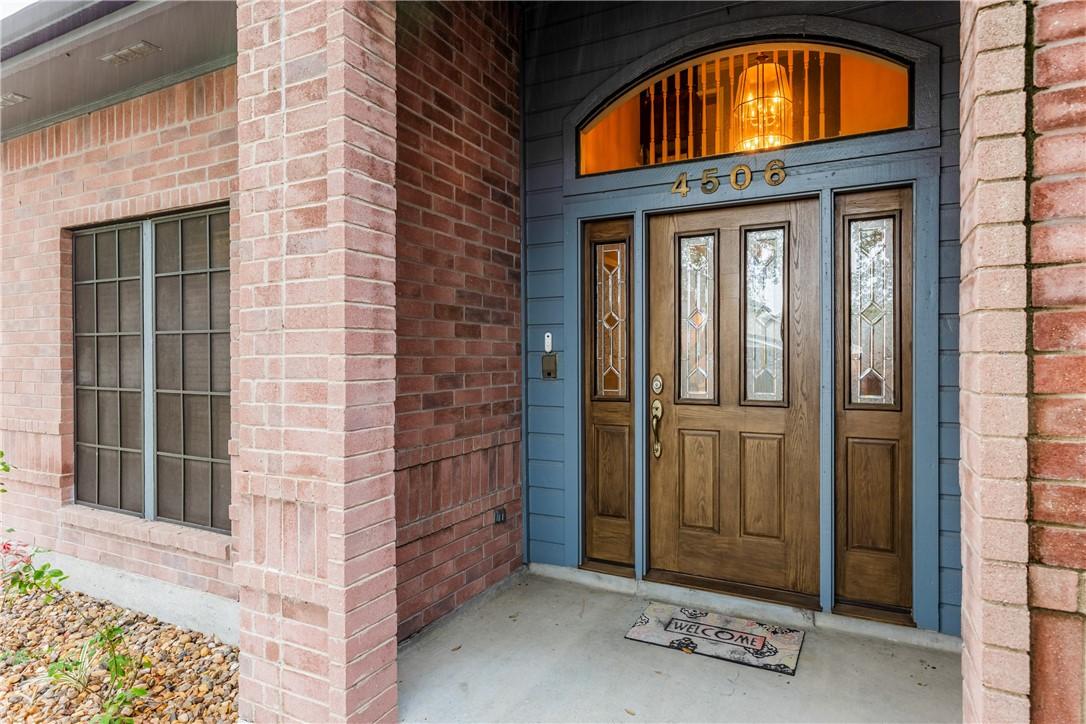 Image 2: Welcoming covered entry with elegant double doors,