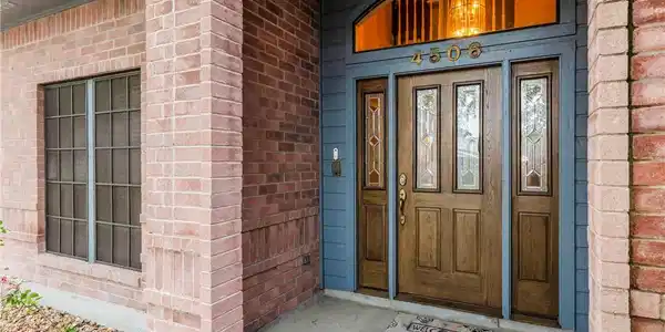 Image 2: Welcoming covered entry with elegant double doors,