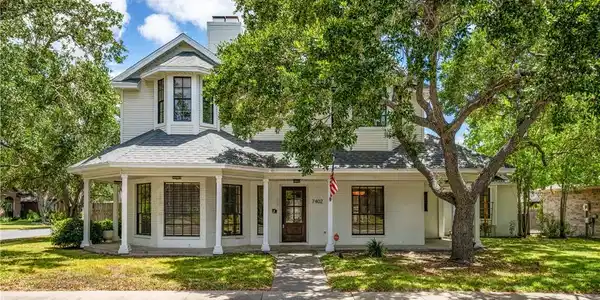 Image 2: A classic two-story traditional home with  a welco