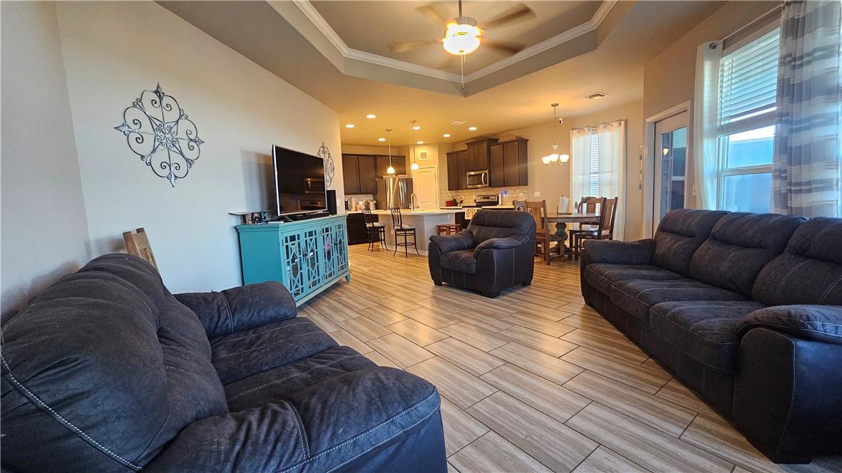 Image 3: The living room has a tray ceiling with a ceiling