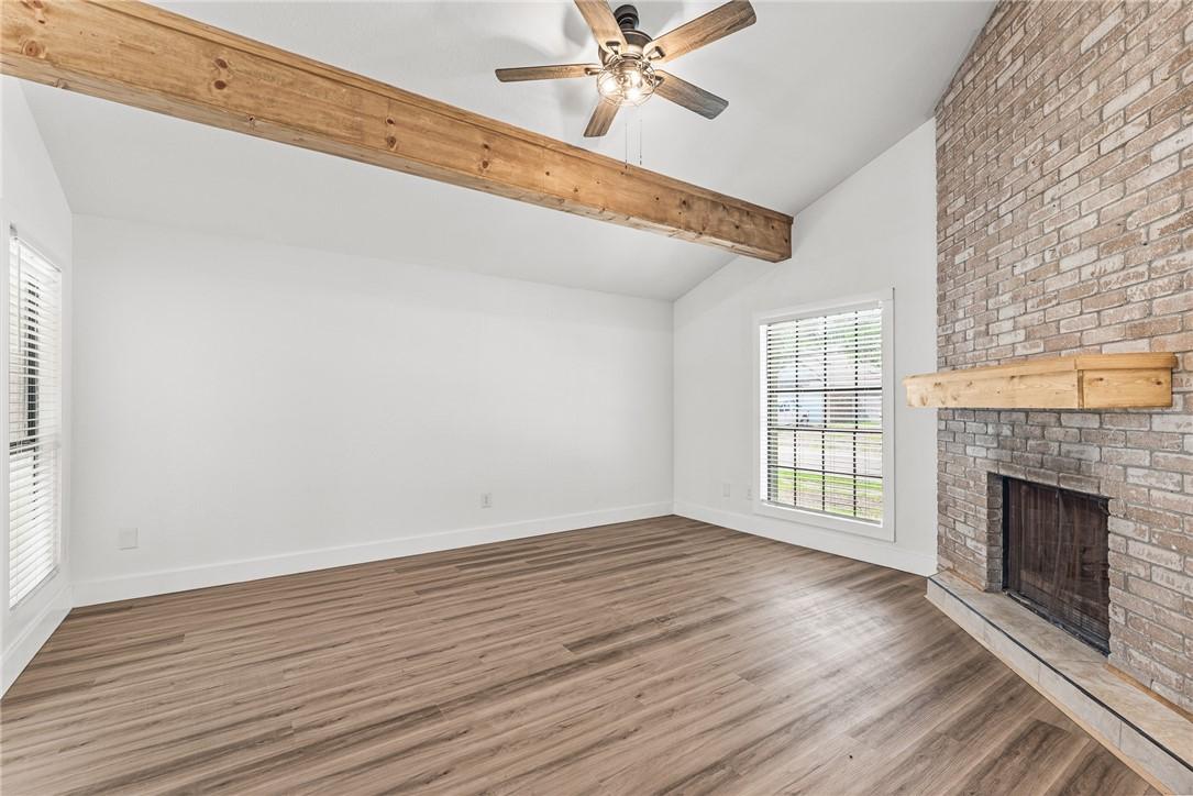 Image 2: Living room with corner wood burning fireplace and
