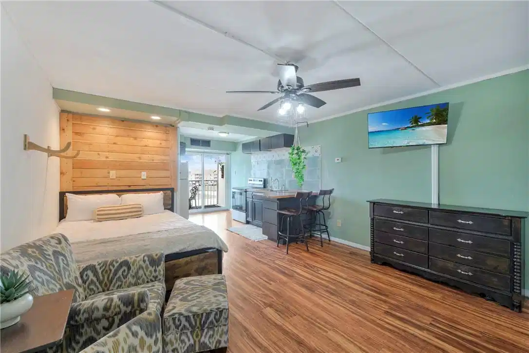 Image 1: Open studio layout &mdash; bed, full kitchen, and living