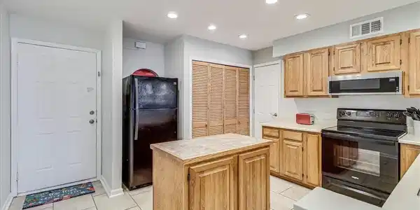 Image 4: Kitchen with island and laundry closet.